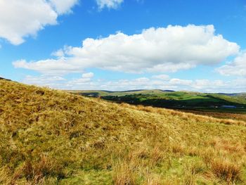 Scenic view of grassy field against cloudy sky