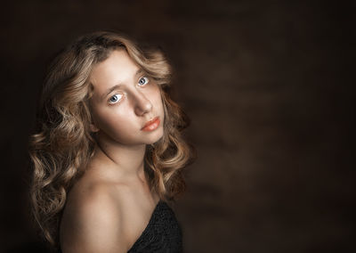 Portrait of beautiful young woman over brown background