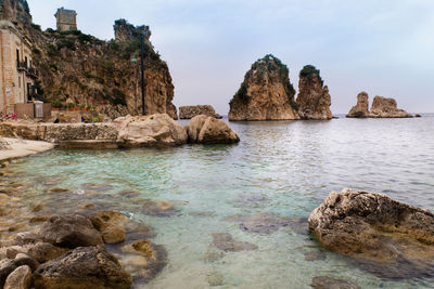 Rocks in sea against sky