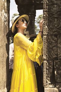 Young woman looking at carving on wall