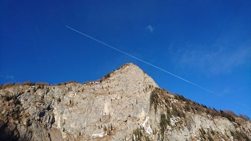 Low angle view of mountain against blue sky