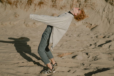 Full length of woman walking on sand at beach