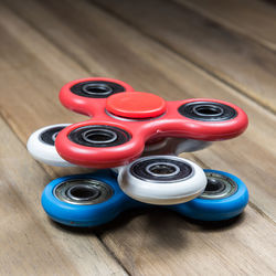 High angle view of colorful fidget spinners on wooden table