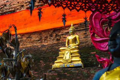 Low angle view of statue against temple building
