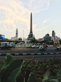 Cars on road in city against sky