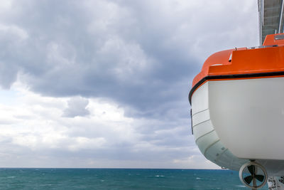 A lifeboat on a passenger cruise ship hangs ready to launch