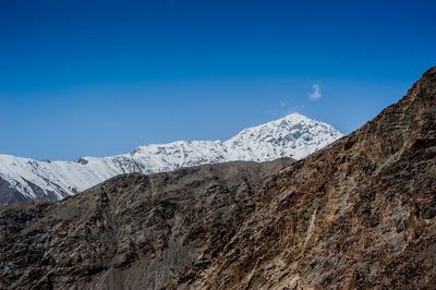 Scenic view of snowcapped mountains against blue sky