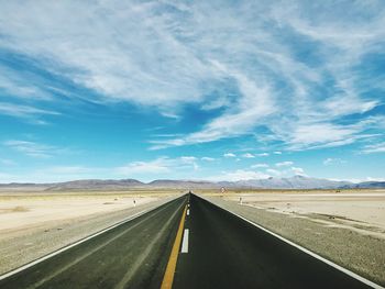 Empty road along countryside landscape