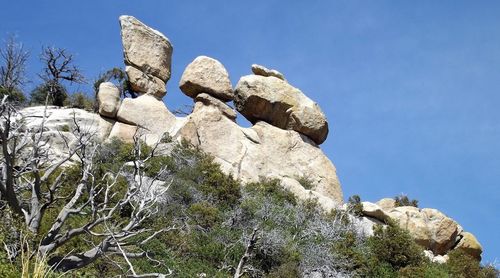 Low angle view of rock formation against clear blue sky