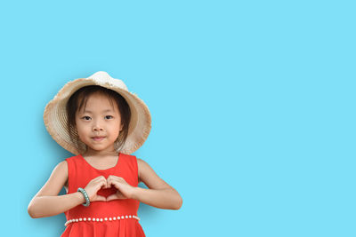 Full length of cute girl standing against blue background