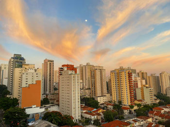 Modern buildings against sky during sunset