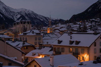 Snow covered houses in town at dusk