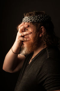 Portrait of man wearing hat against black background