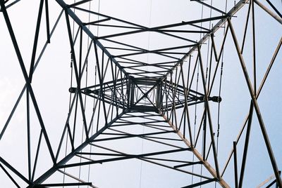 Low angle view of electricity pylon against clear sky