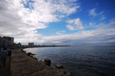 Scenic view of sea by city against sky