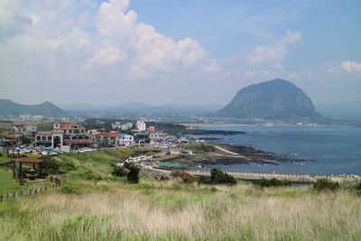 Scenic view of sea by mountains against sky