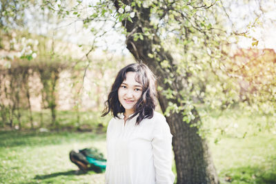 Happy young woman in a white blouse in a park. springtime