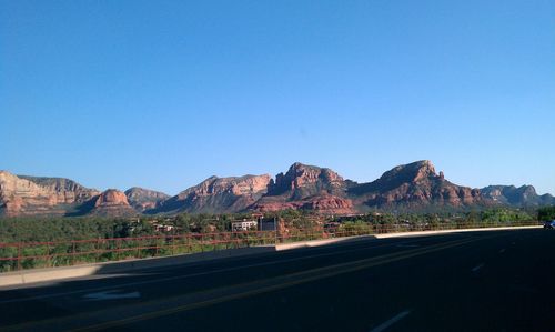 Road by mountains against clear blue sky