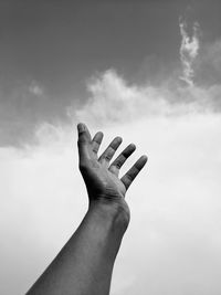 Cropped hand of person reaching towards sky