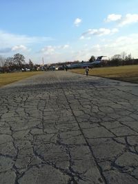 Surface level of road on field against sky
