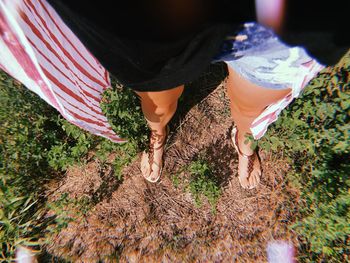 Low section of woman standing on field