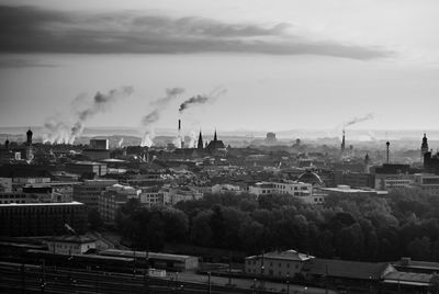 High angle view of buildings and factories against sky at dusk