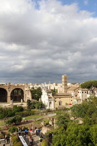 Buildings in city against cloudy sky