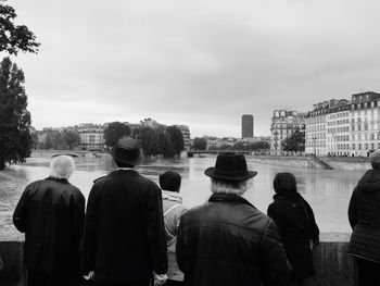 Rear view of people in city against sky