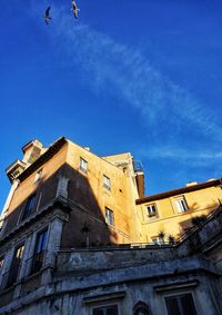 Low angle view of historic building against blue sky