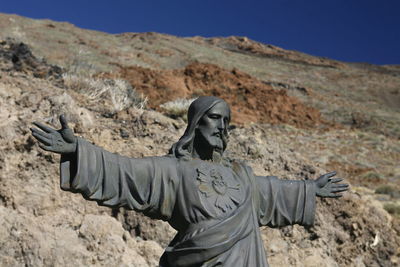 Low angle view of jesus christ statue against mountain