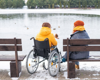 Rear view of man sitting on bench