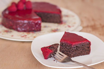 A slice of chocolate cake with raspberry glaze.