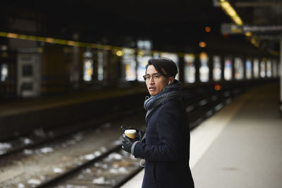 Smiling man standing at train platform