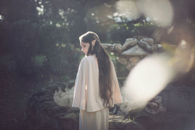 Thoughtful fairy elf young woman standing at park