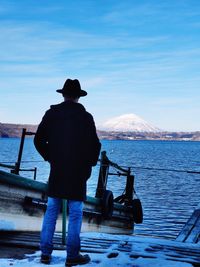 Rear view of man looking at sea against sky