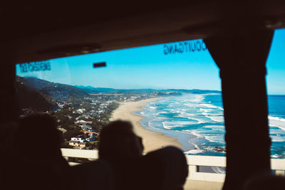 Scenic view of beach seen through window