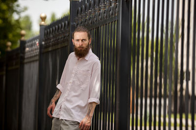 Portrait of young man standing against wall