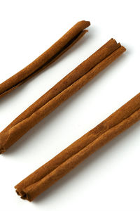 Close-up of bread on wood against white background