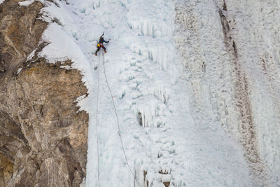 Woman climbs cliff at ice park in lake city, colorado