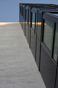 Empty footpath amidst buildings against clear sky