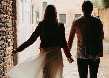 Rear view of couple walking in city