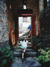 Rear view of woman walking on staircase of building