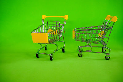Empty chairs against green background