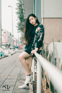 Portrait of young woman sitting outdoors