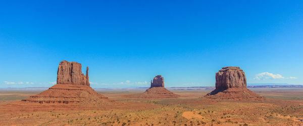 Rock formations on landscape against blue sky
