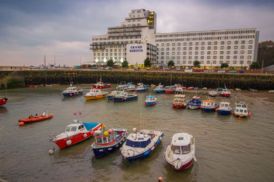 High angle view of boats moored in river against buildings