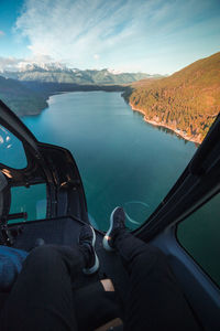 Low section of person in lake against sky