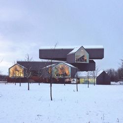 Built structure on snow field against sky