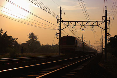 Railroad tracks against sky during sunset