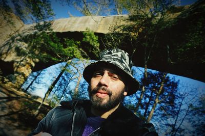 Portrait of young man against trees